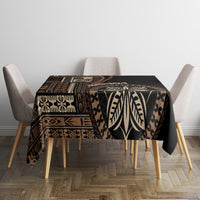 Black tablecloth with geometric borders and leaf motifs across the tabletop