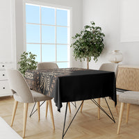 Black tablecloth with patterned border and leaf-and-geometry design on a dining table