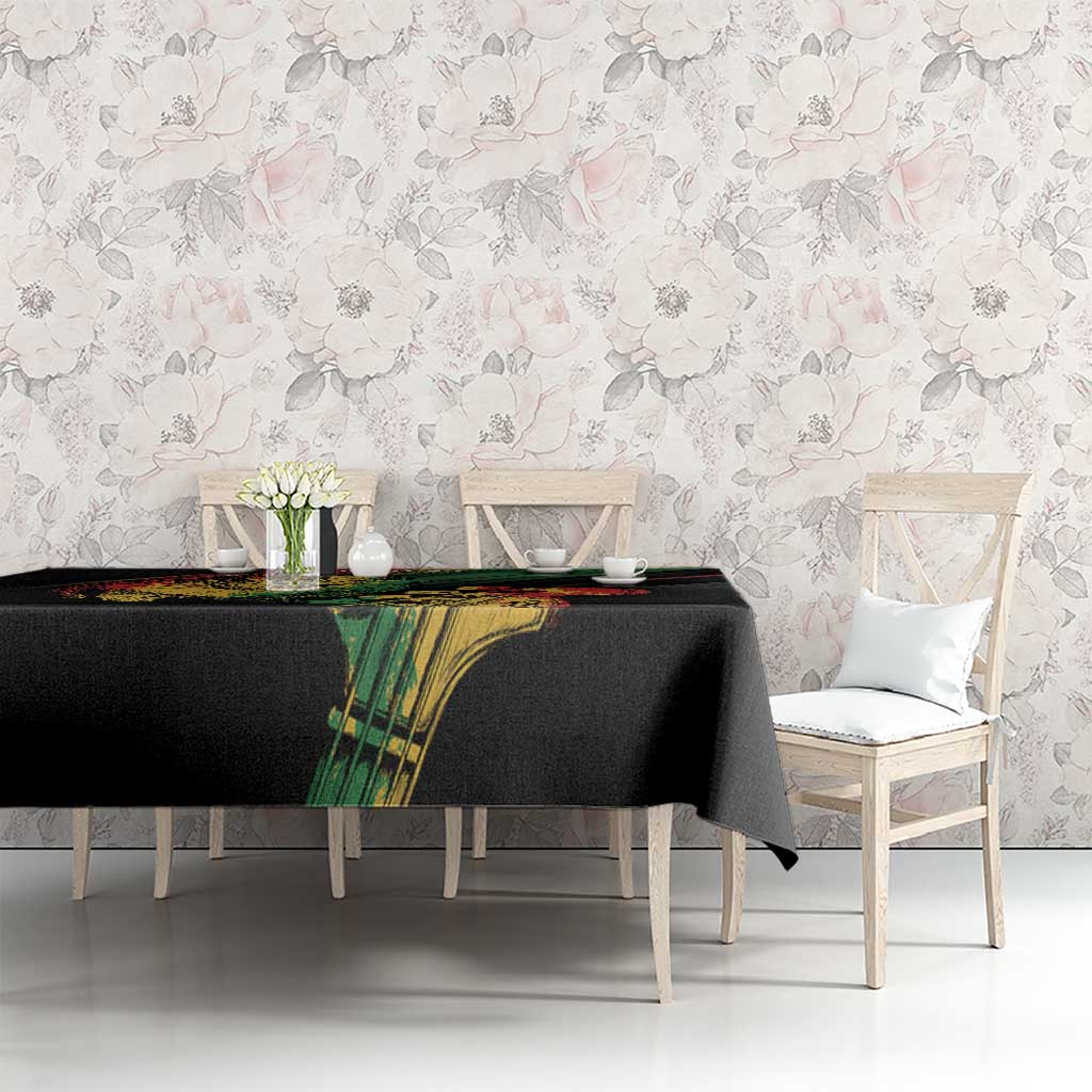 Reggae-themed tablecloth with black fabric, colorful green panel graphic, and red-green stripe trim
