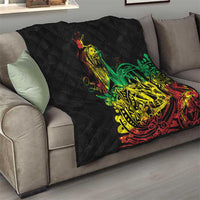 Black quilt with diamond pattern and reggae dancer artwork in green, yellow, and red on a sofa.