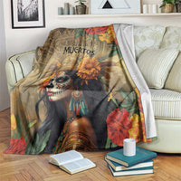 Dia de los Muertos blanket on couch showing skull-faced goddess and large red flowers