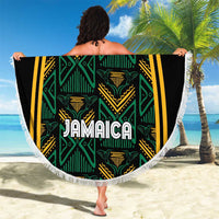 Round beach blanket with white fringe, bold “JAMAICA” center on black-green geometric print