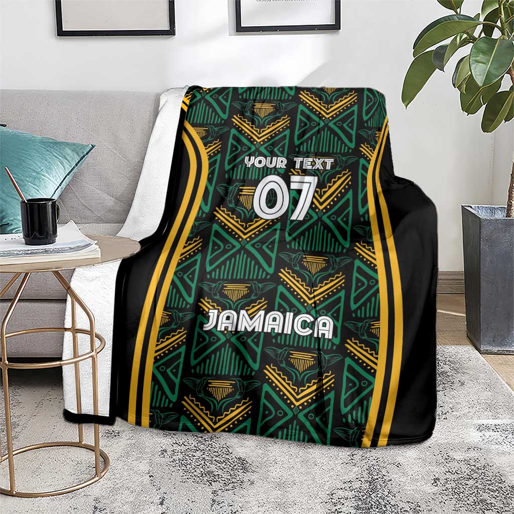 Jamaica reggae blanket folded on floor, teal and gold pattern with black sides