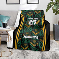 Jamaica reggae blanket folded on floor, teal and gold pattern with black sides