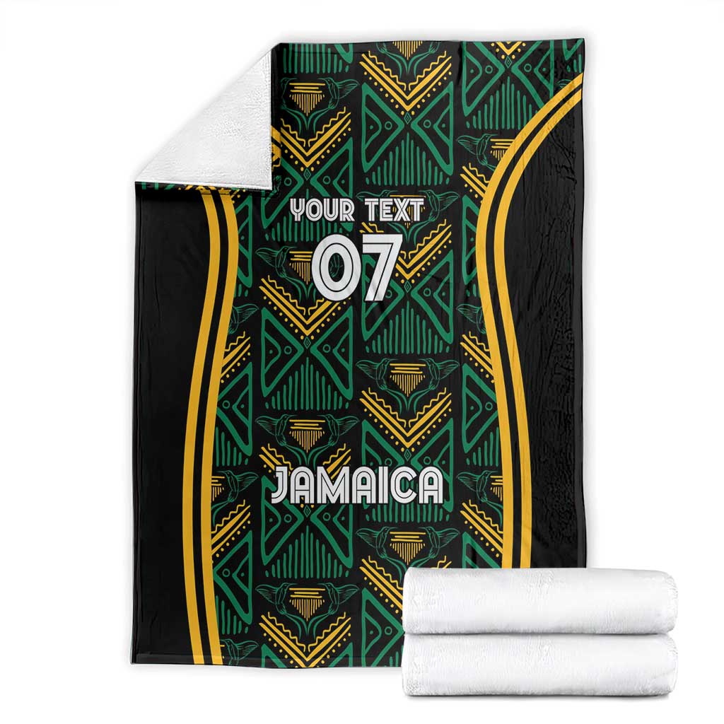 Jamaica reggae blanket and folded white towels, teal geometric motifs on black