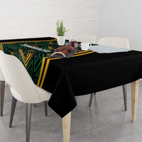 Black tablecloth with green and gold patterned strip and overhanging drape