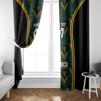 Pair of black curtains with green patterned panels and gold trim covering a window