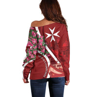 Red off-shoulder sweater with Malta graphic and floral pattern on sleeves