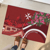 Red rubber doormat on concrete, Malta skyline and boat with pink flowers and white emblem