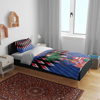Blue Christmas bedding set on bed with zigzag design, pine wreath, and gift graphics