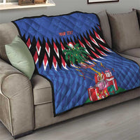 Blue quilt laid over sofa with zigzag stripes, palm tree graphic, and wrapped gifts