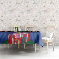Blue Christmas tablecloth featuring gifts, green accents, and chevron pattern on table
