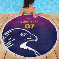 Round beach blanket with navy falcon head print, white fringe border, custom text 07 and UAE flag