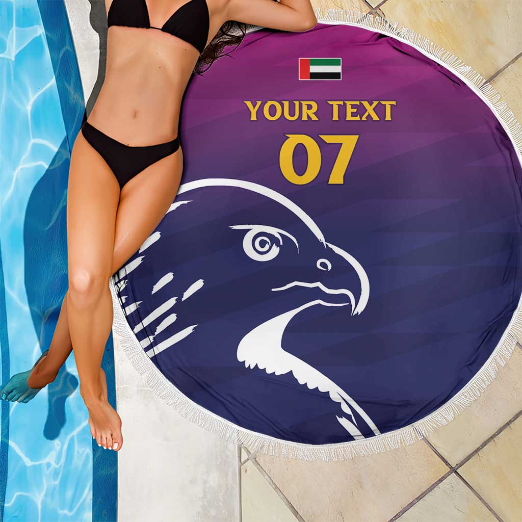Round beach blanket partially shown with purple/navy falcon print, white fringe, custom text 07