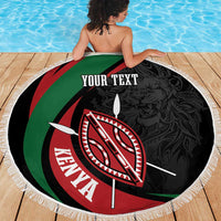 Round black beach blanket with green-red stripes, Kenya shield emblem, and white fringe