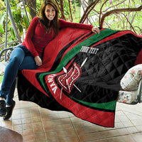 Personalized quilt blanket on couch, black/red/green lion shield graphic with “YOUR TEXT”