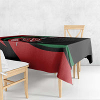 Personalized tablecloth over table edge, black with red and green diagonal shield graphic