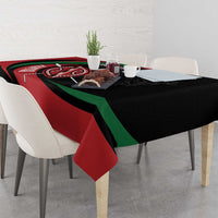 Personalized tablecloth on dining table, black base with red and green warrior shield design