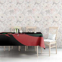 Personalized tablecloth draped on table, featuring black with red and green shield design