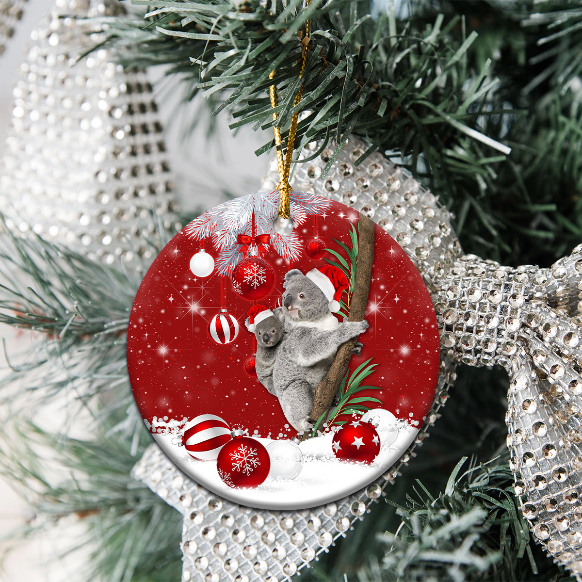 Red ceramic round koala Santa ornament on evergreen branch with gold loop