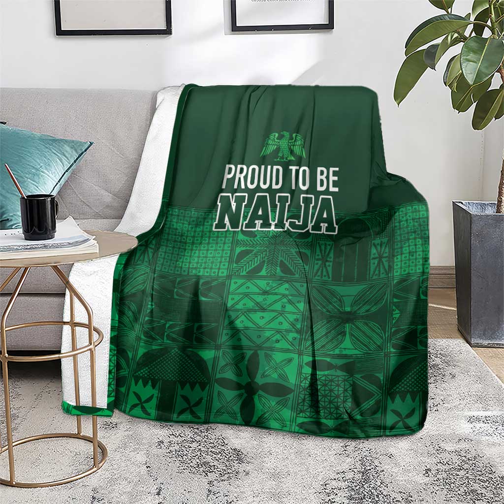 Dark green adire-pattern blanket with 'Proud to be Naija' text and grid-like design