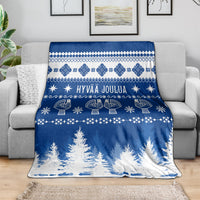Blue Christmas blanket with Finnish festive pattern, text, and tree border