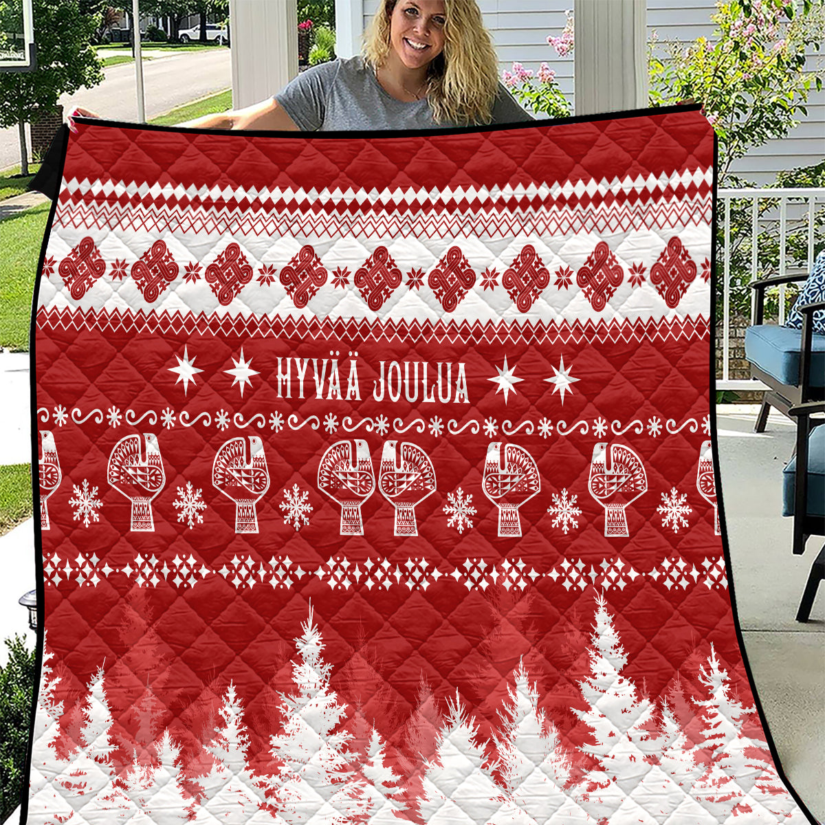 Red and white Christmas quilt with 'HYVAA JOULUA' text, reindeer and fir trees