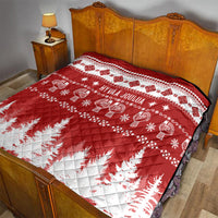 Quilt on bed with red and white Christmas design, 'HYVAA JOULUA' and pine trees