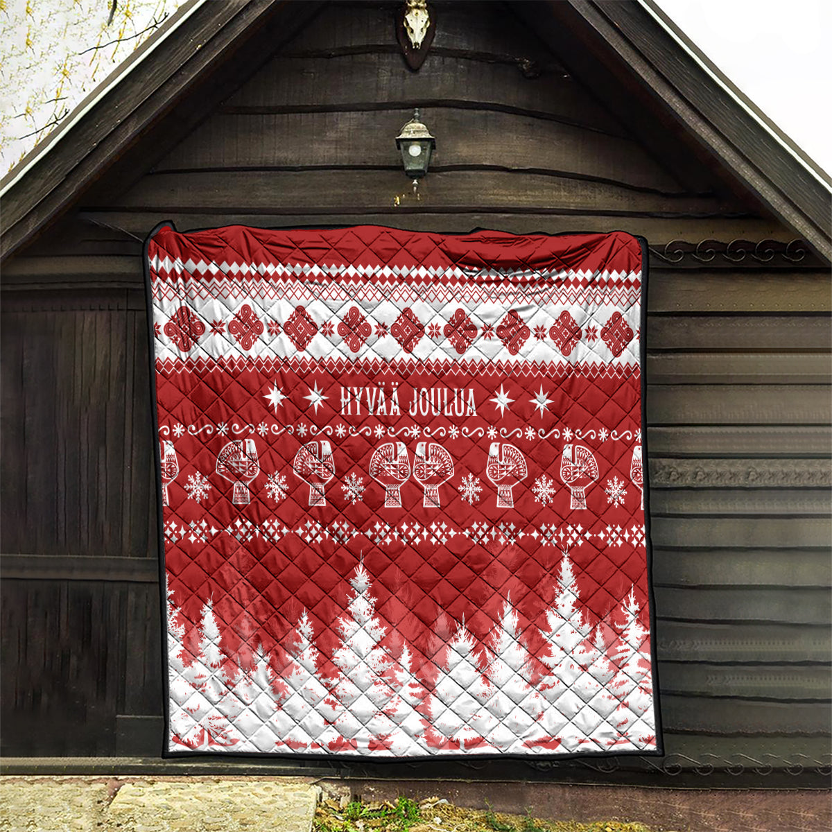 Red and white Christmas quilt with 'HYVAA JOULUA' center, reindeer and star patterns