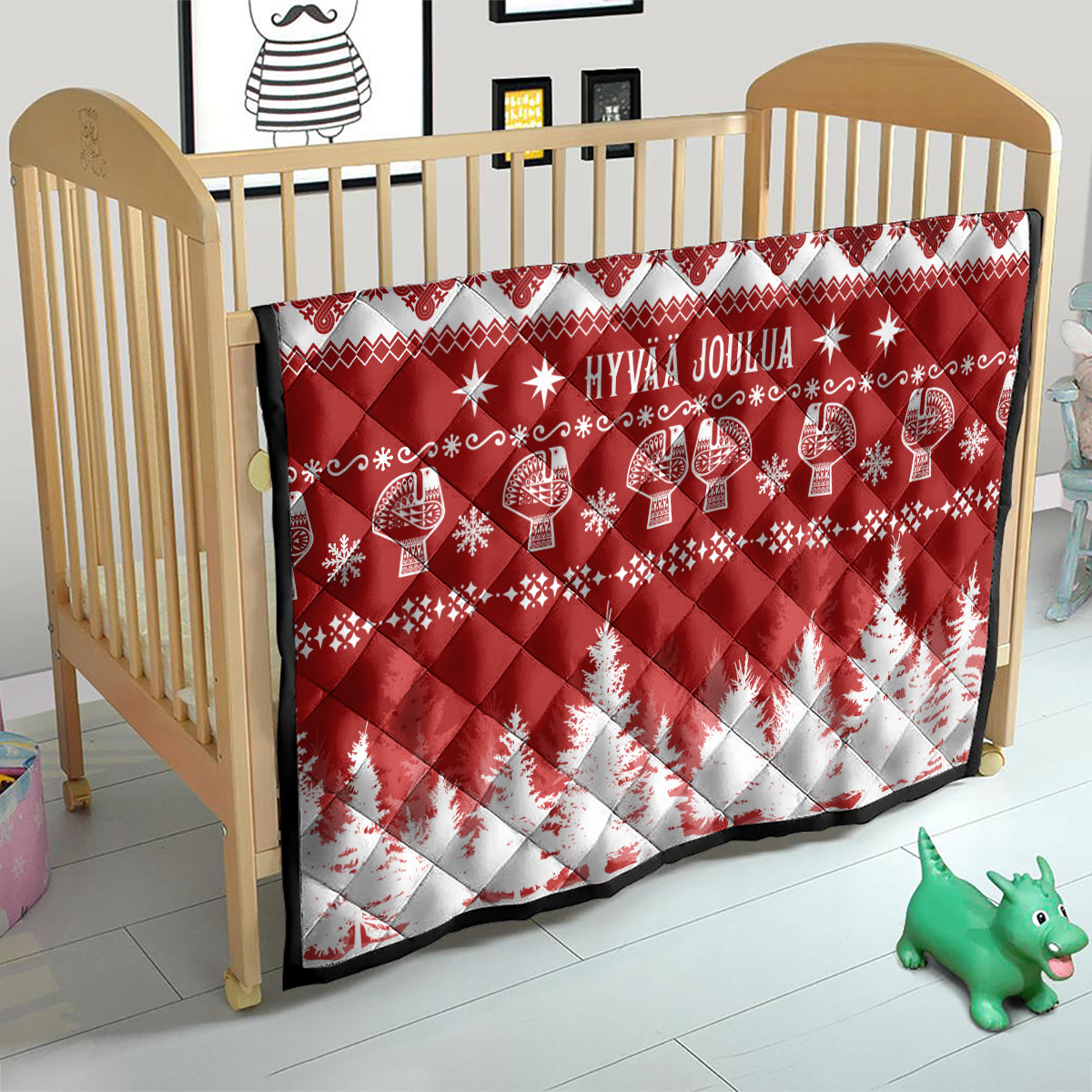 Red and white Christmas quilt on crib with 'HYVAA JOULUA' and reindeer pattern