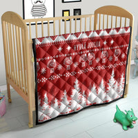 Red and white Christmas quilt on crib with 'HYVAA JOULUA' and reindeer pattern