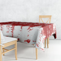 Red and white Christmas tablecloth draped on table, snowy trees and brushstroke print
