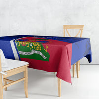 Blue and red Haiti flag tablecloth draped on dining table with hibiscus trim.
