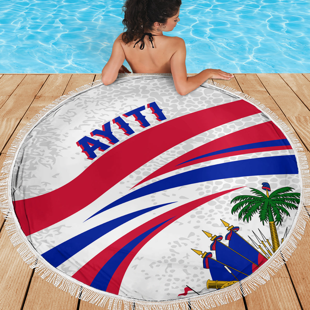White round beach blanket on deck boards with fringe edge, Haiti flag graphic