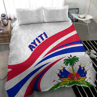 White bedding set with patterned pillows and large Haiti flag banner, palm centerpiece