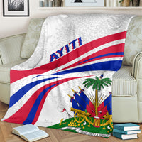 Haiti flag style throw blanket on a living room couch, light gray with flag stripes and emblem.