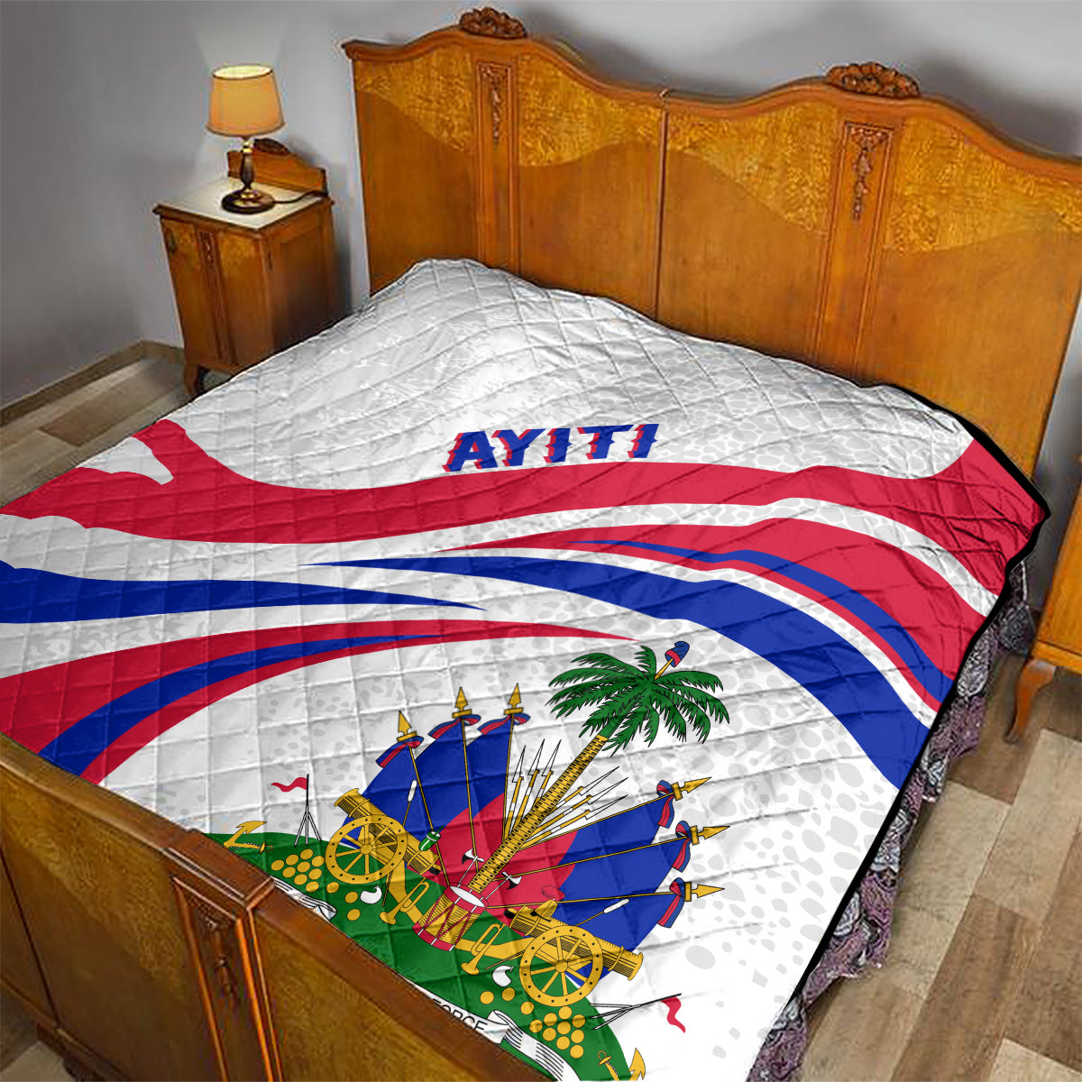Haiti Independence quilt on bedspread, white with red/blue flag curves and 'AYITI'.