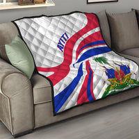 Haiti Independence quilt draped on a sofa, white with red/blue flag curves and coat-of-arms.