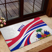 Haiti-themed rubber doormat on entryway step, flag rays with AYITI lettering and crest