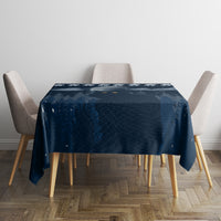Dark blue Christmas tablecloth draped over table with snowy night design