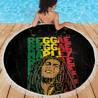 Black round beach blanket with white fringe edge and colorful reggae type artwork