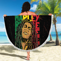 Black round beach blanket with white fringed border, colorful reggae text graphic