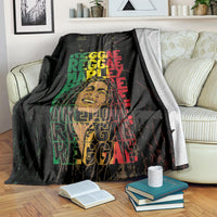 Black reggae blanket draped over a sofa, showing large green and red stacked typography