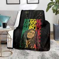 Black reggae blanket laid on the floor, large green, red, and yellow reggae lettering