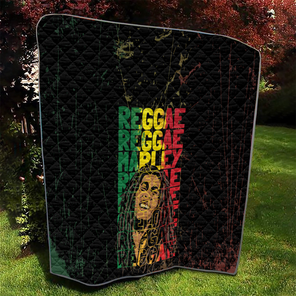 Black quilt with diamond quilting and reggae lettering around a central portrait graphic