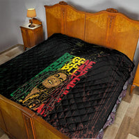 Black quilt on bed with diamond stitching and multicolor REGGAE text over a portrait