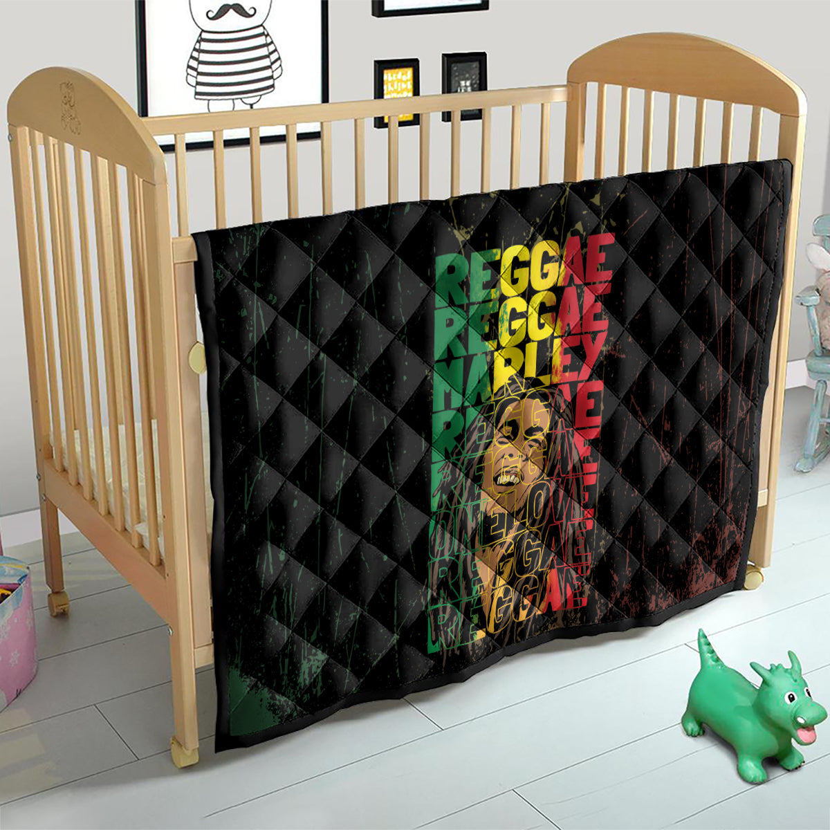 Black quilt on crib with diamond stitching and stacked multicolor REGGAE text with face artwork