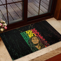 Black rubber doormat with stacked reggae text collage and yellow face grunge print