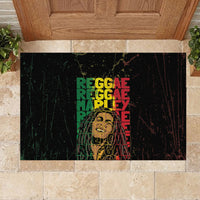 Black rubber doormat with centered multicolor reggae text and distressed grunge design