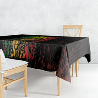 Black tablecloth draped on a dining table with colorful reggae-style lettering.
